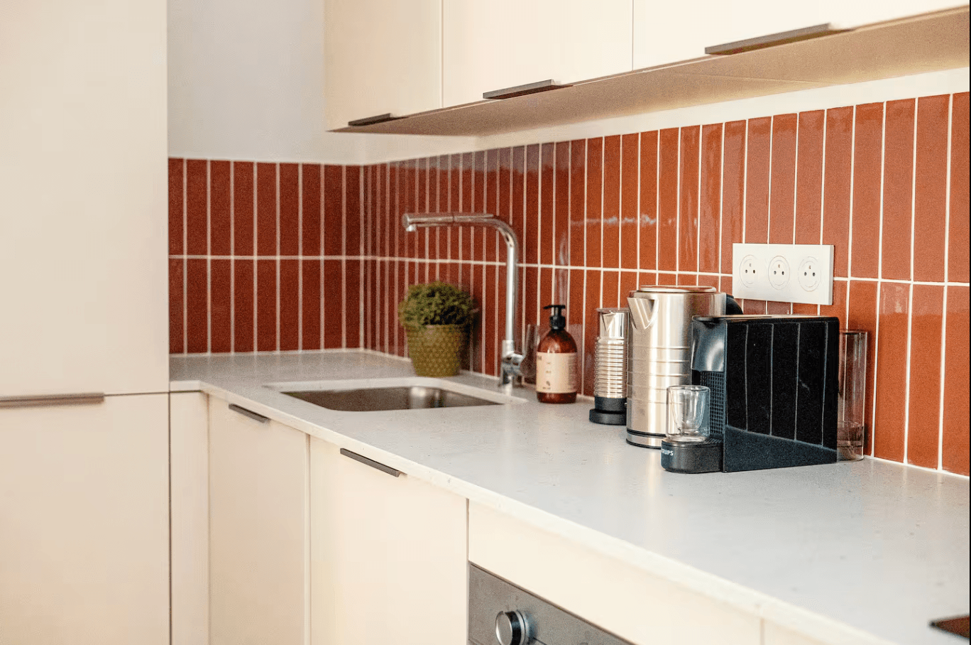 Détail cuisine avec crédence verticale terracotta et électroménager