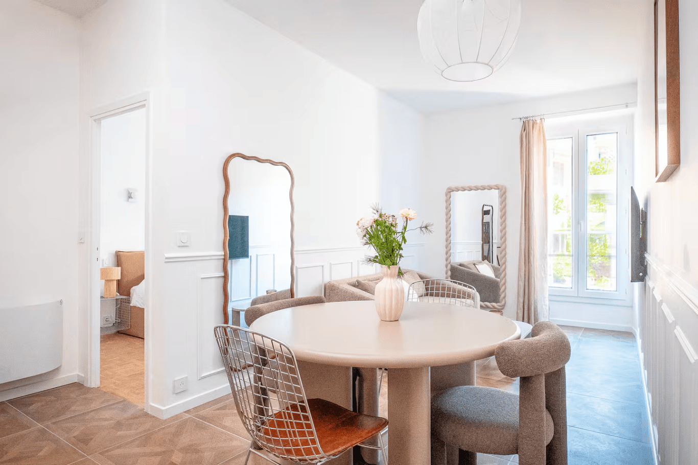 Salon ouvert sur cuisine avec table ronde et décoration soignée