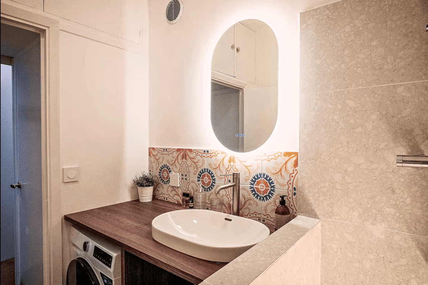 Salle d'eau avec carreaux de ciment et miroir LED