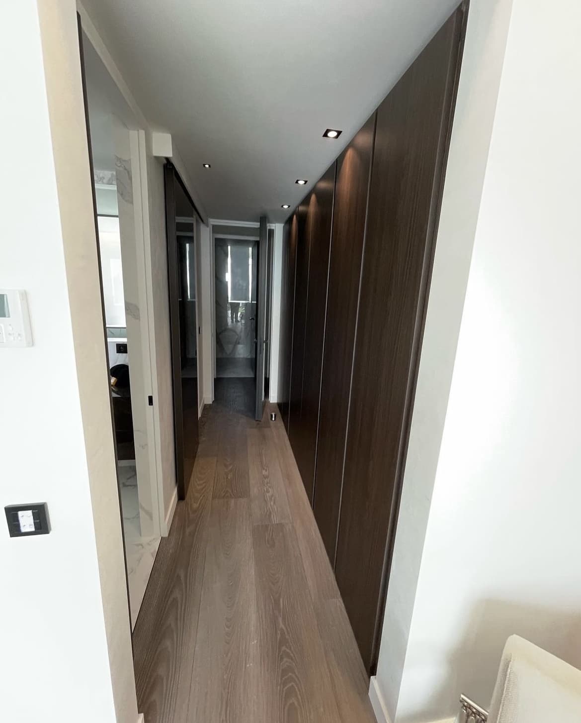 Rénovation intérieure appartement Menton - Couloir moderne avec placards bois sombre et parquet - UDK Azur