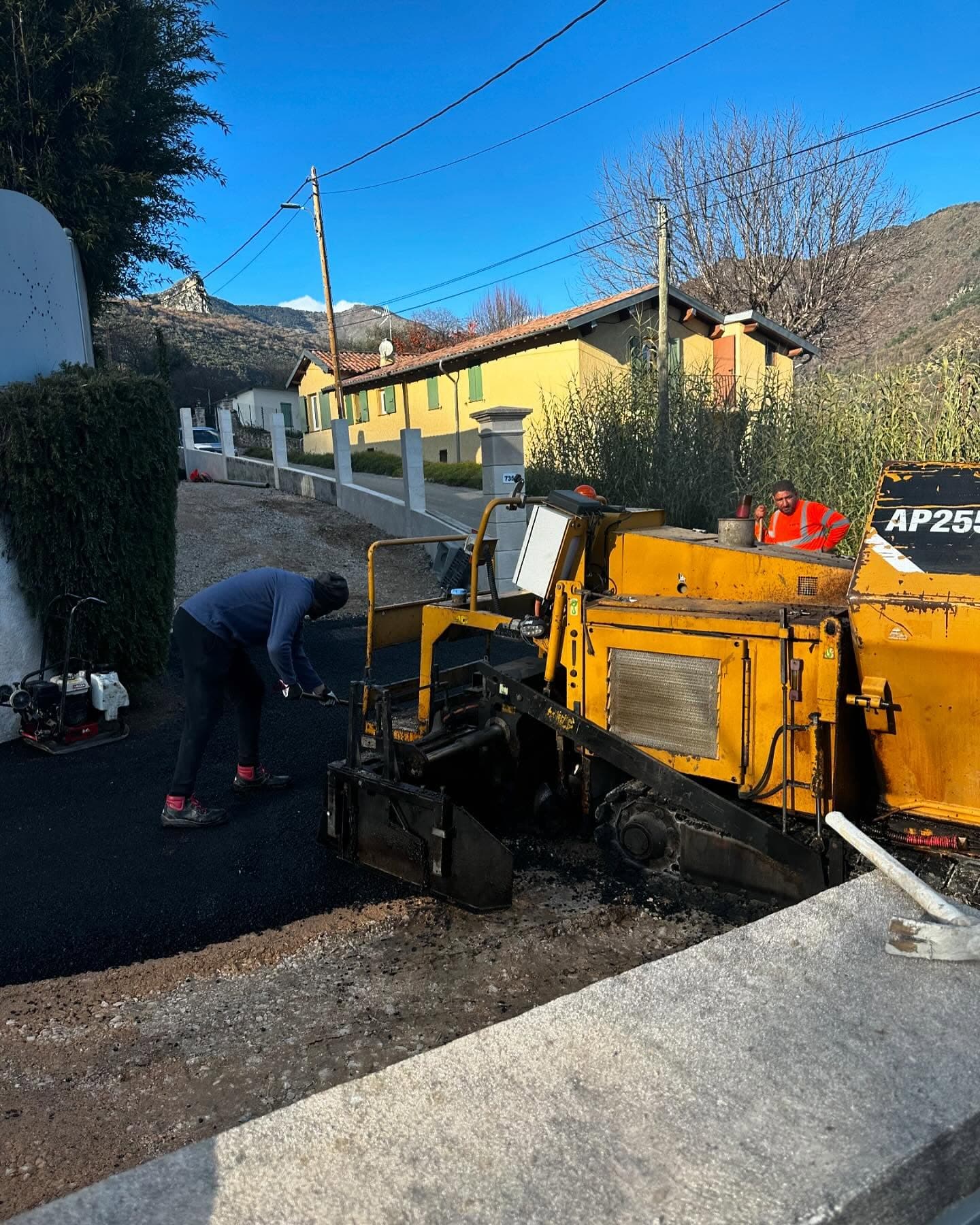 Travaux de terrassement et VRD à Menton : finisseuse jaune AP255 en action sur chantier résidentiel