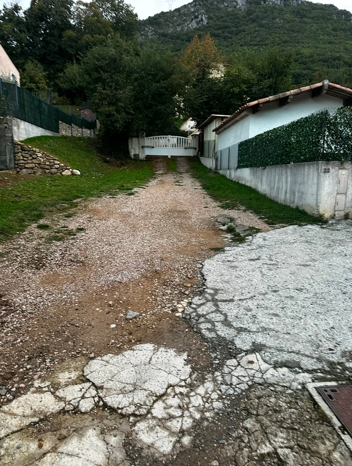 Chemin en grave et béton fissuré avant travaux de voirie