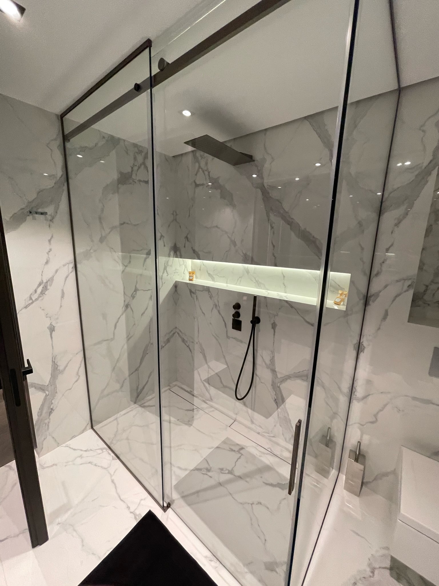 Douche à l'italienne avec marbre blanc et robinetterie noire à Menton par UDK Azur