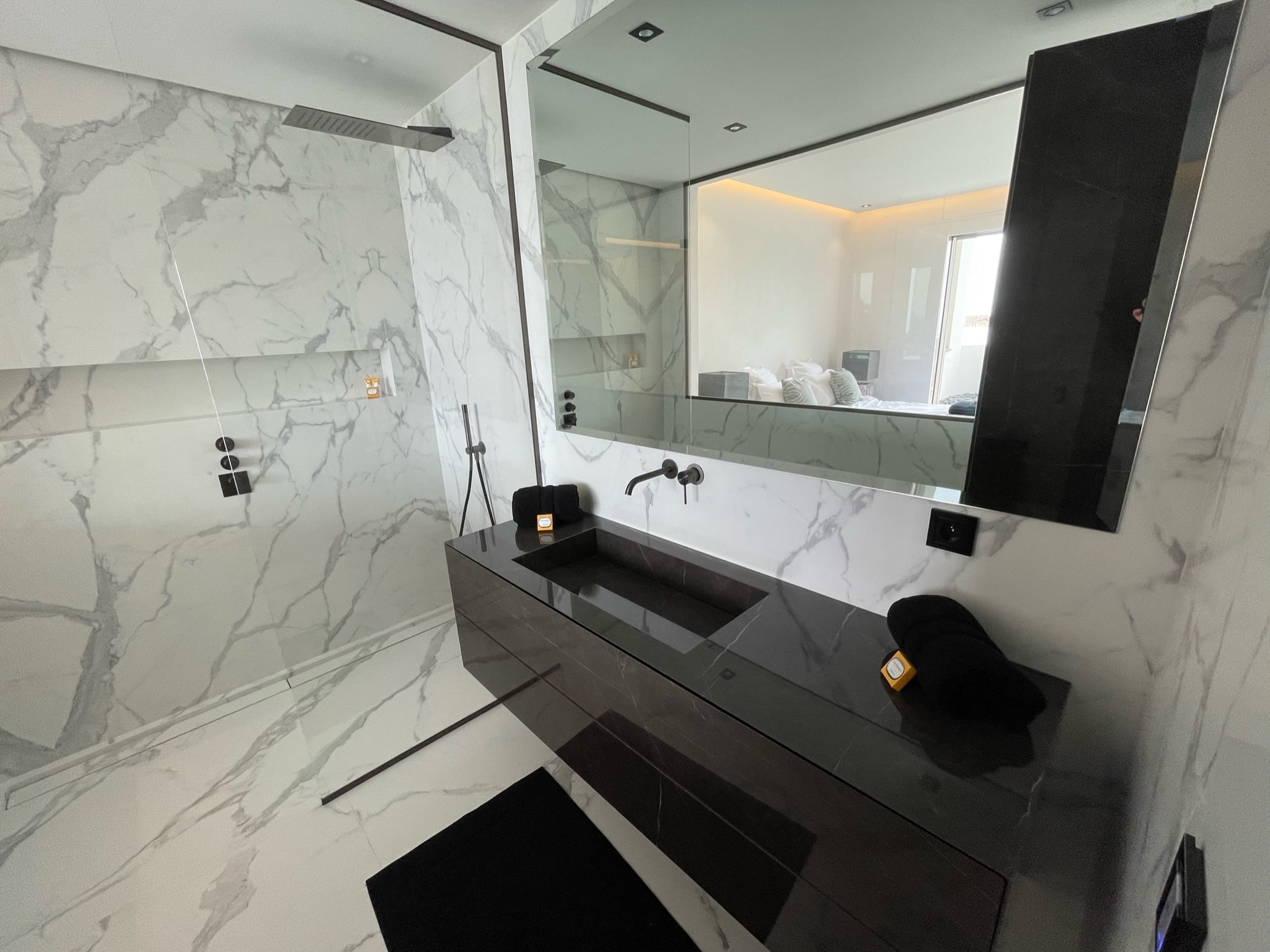 Salle de bain moderne avec double vasque noire et marbre blanc à Menton par UDK Azur