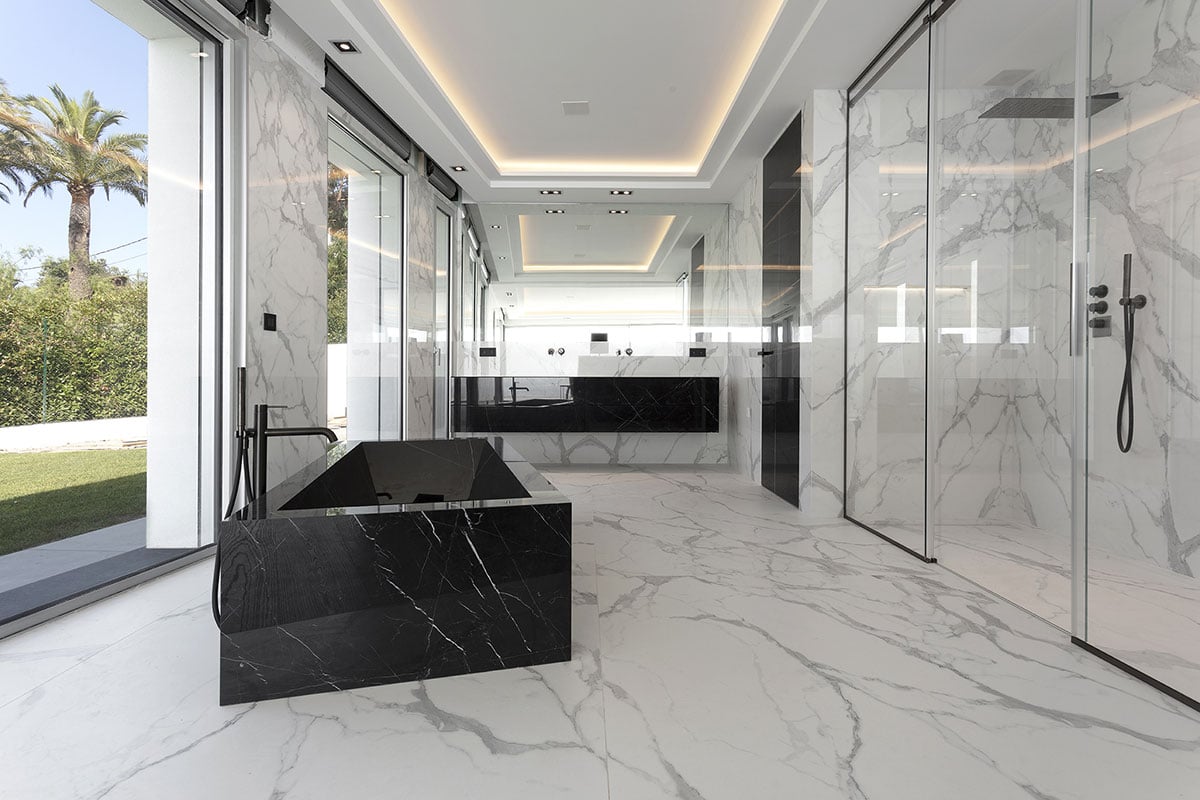 Grande salle de bain luxueuse avec baignoire îlot noire et éclairage LED à Roquebrune-Cap-Martin